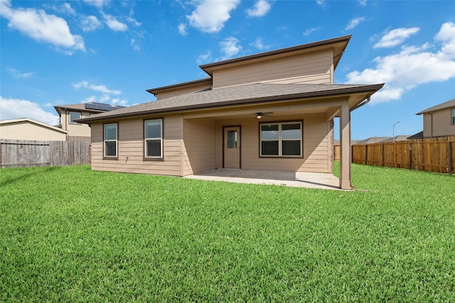 back of property with a patio area, a fenced backyard, a lawn, and ceiling fan