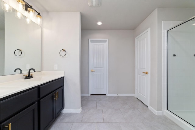 full bath with a sink, tiled shower, double vanity, and tile patterned flooring