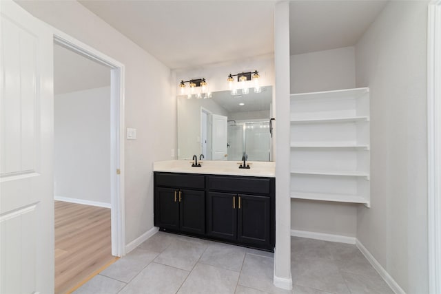 full bath featuring tile patterned flooring, a shower stall, vanity, and baseboards