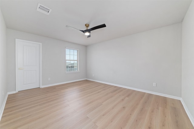 spare room with light wood-type flooring, visible vents, baseboards, and ceiling fan