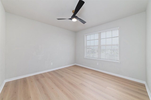 spare room with light wood finished floors, ceiling fan, and baseboards