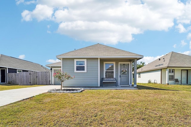 view of front of property featuring driveway, an attached garage, a front yard, and fence