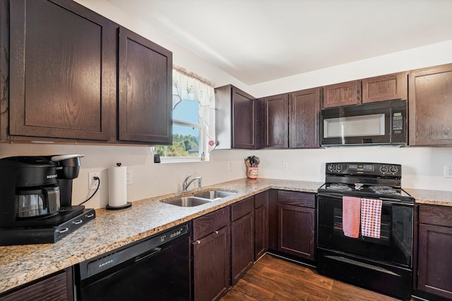 kitchen featuring black appliances, a sink, light stone counters, dark brown cabinets, and dark wood-style flooring