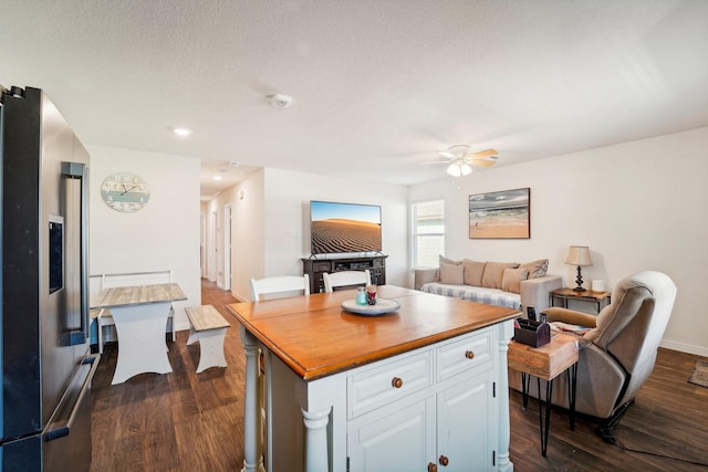 kitchen featuring butcher block countertops, dark wood finished floors, white cabinetry, stainless steel fridge, and ceiling fan