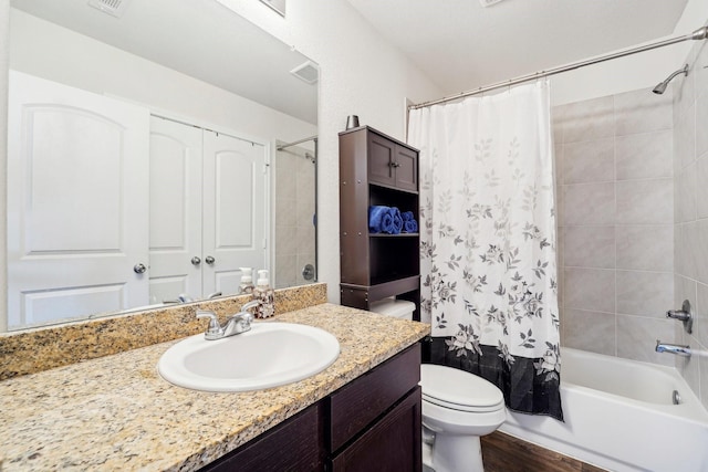 bathroom featuring visible vents, toilet, shower / bath combo, wood finished floors, and vanity