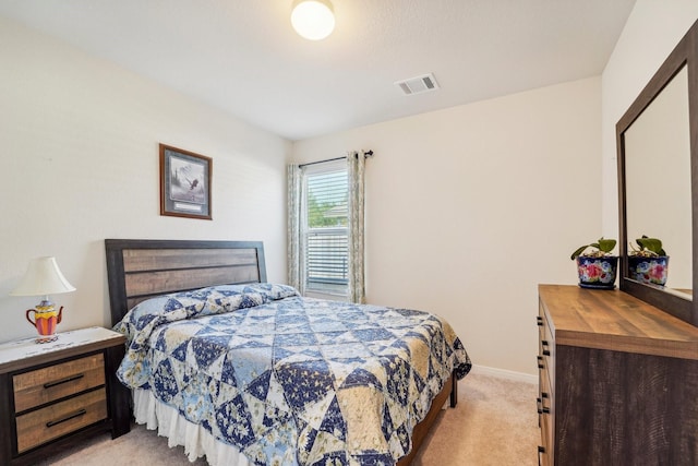 bedroom featuring baseboards, visible vents, and light carpet