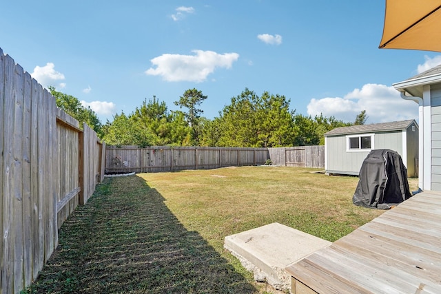 view of yard featuring a storage unit, an outdoor structure, and a fenced backyard