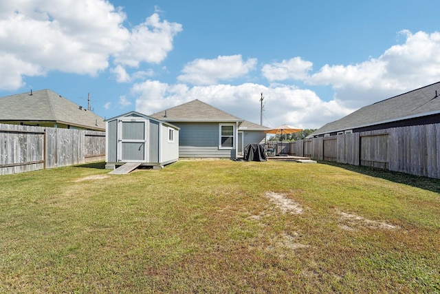 view of yard with a storage shed, an outdoor structure, and a fenced backyard