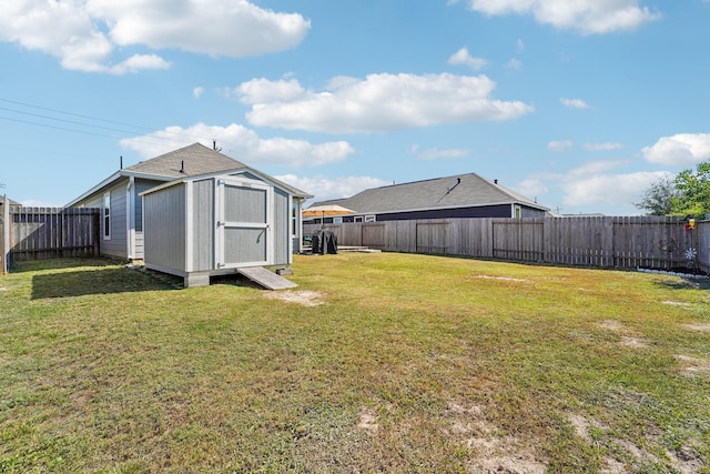 view of yard featuring an outbuilding, a fenced backyard, and a shed