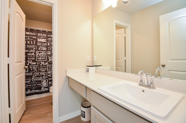 bathroom with visible vents, baseboards, toilet, wood finished floors, and vanity