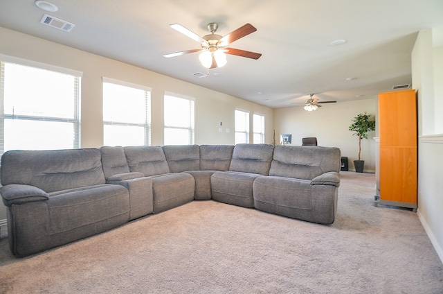 carpeted living area with visible vents and ceiling fan