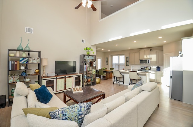 living area with recessed lighting, visible vents, light wood-style flooring, and ceiling fan