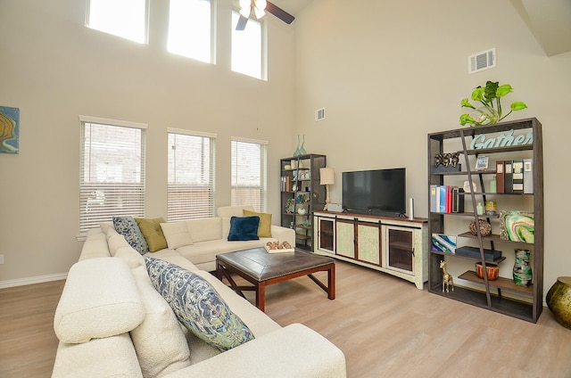 living area with ceiling fan, visible vents, a healthy amount of sunlight, and wood finished floors