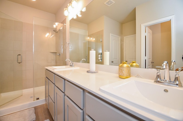 bathroom featuring a shower stall, double vanity, visible vents, and a sink