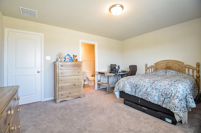 carpeted bedroom featuring visible vents and ensuite bathroom