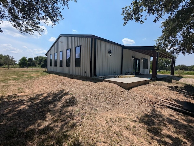 view of side of property with a patio area and board and batten siding