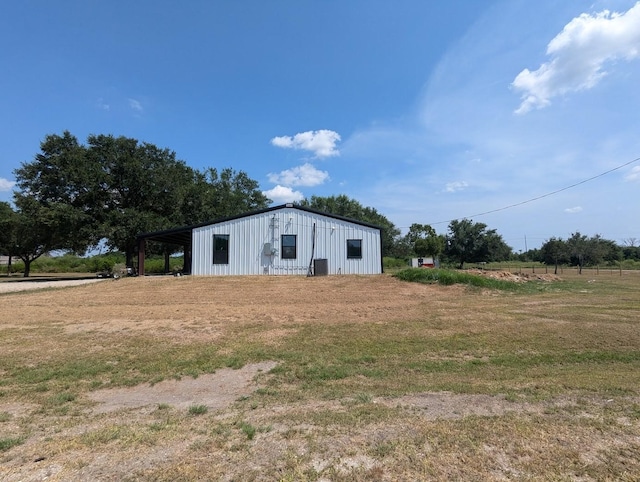 view of pole building with a carport and a yard