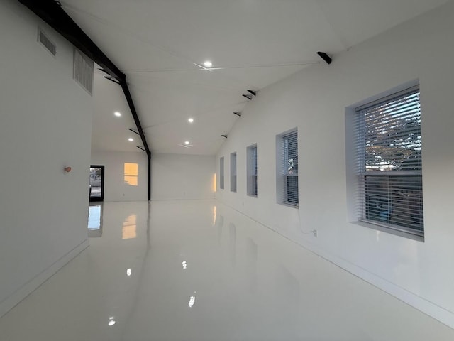 corridor with visible vents, recessed lighting, and vaulted ceiling