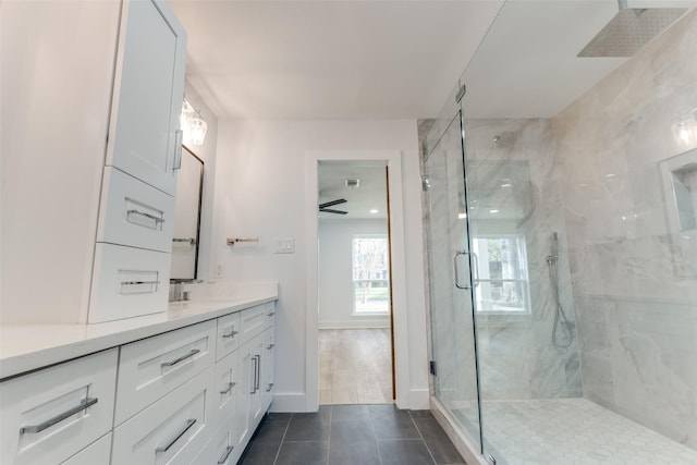 full bathroom with vanity, visible vents, baseboards, a marble finish shower, and tile patterned flooring