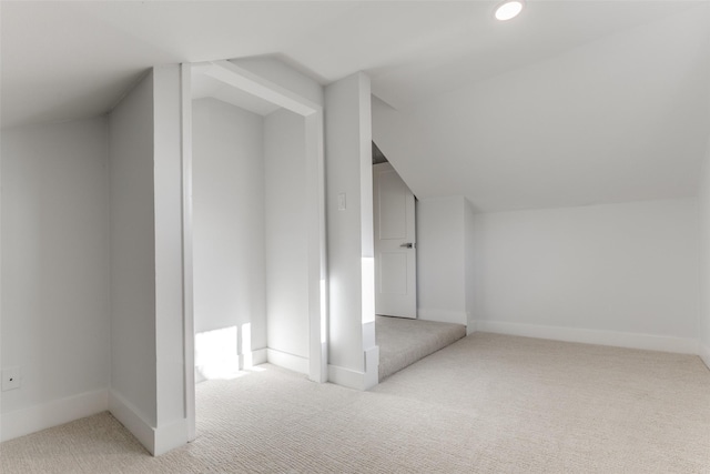 additional living space featuring baseboards, carpet flooring, and vaulted ceiling