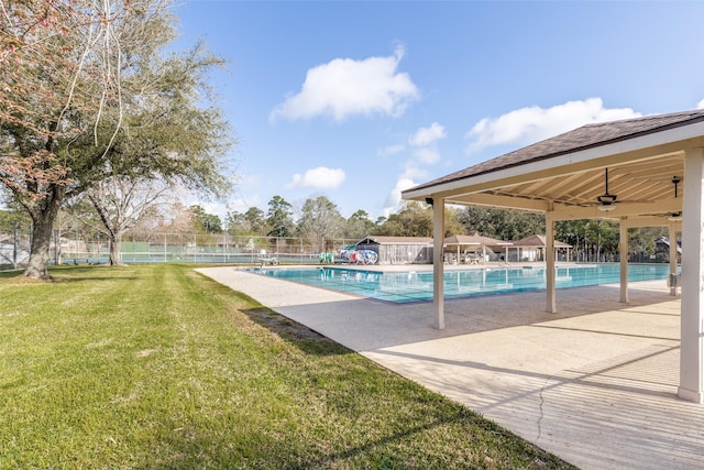 pool featuring a lawn, ceiling fan, a patio, and fence