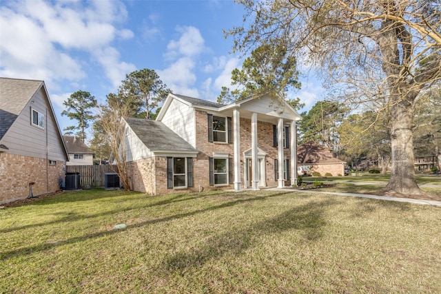 neoclassical home with brick siding, cooling unit, a front lawn, and fence