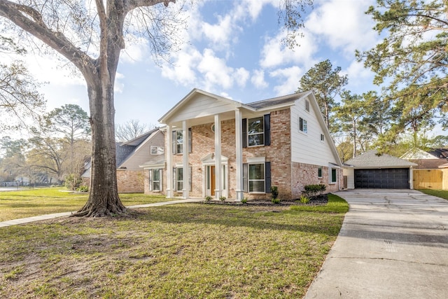 neoclassical home with an outbuilding, a garage, brick siding, and a front lawn