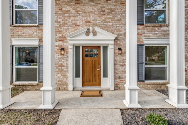 doorway to property featuring brick siding