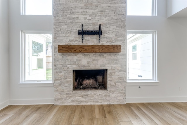 interior details featuring a fireplace, baseboards, and wood finished floors