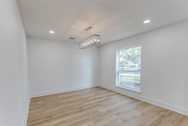 empty room featuring visible vents, light wood-style flooring, recessed lighting, an inviting chandelier, and baseboards