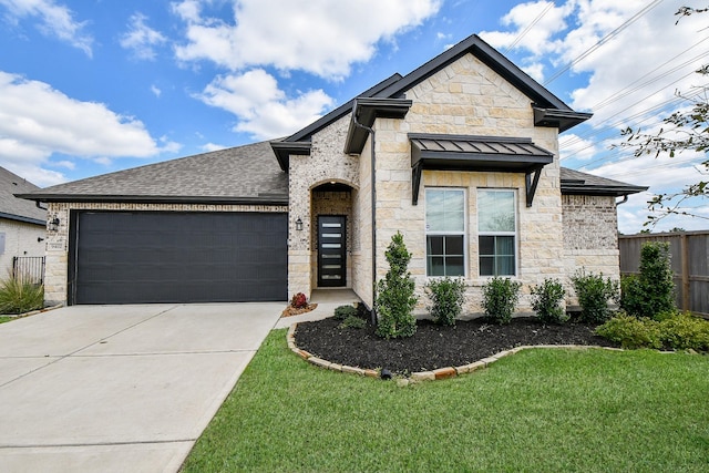 view of front of home with a front lawn, stone siding, roof with shingles, concrete driveway, and an attached garage