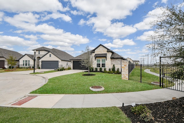 french country inspired facade with driveway, an attached garage, a front lawn, and fence