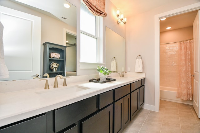 bathroom with a sink, visible vents, double vanity, and tile patterned floors