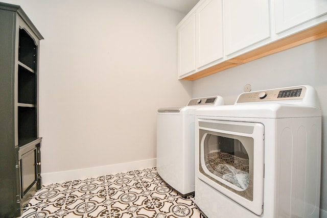 laundry room with light tile patterned floors, baseboards, cabinet space, and washer and dryer