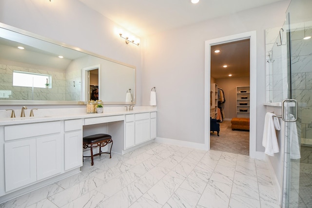 bathroom featuring a spacious closet, a stall shower, marble finish floor, and a sink