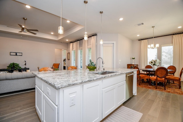 kitchen with wood finished floors, a center island with sink, a sink, dishwasher, and open floor plan