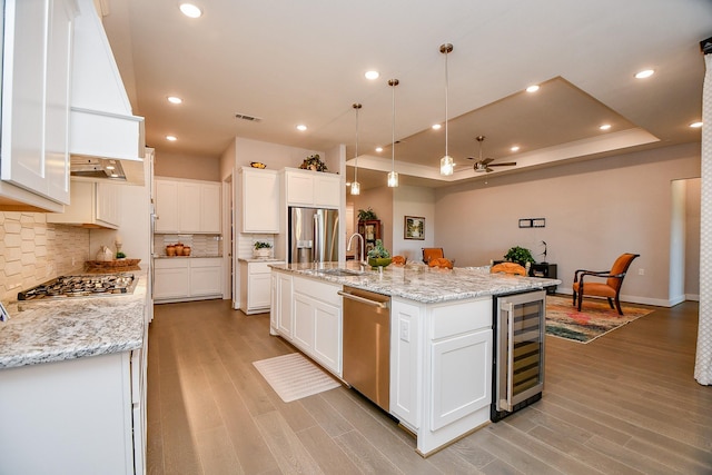 kitchen featuring visible vents, a sink, wine cooler, appliances with stainless steel finishes, and ceiling fan