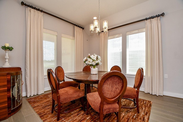 dining room featuring baseboards, a chandelier, and dark wood-style flooring