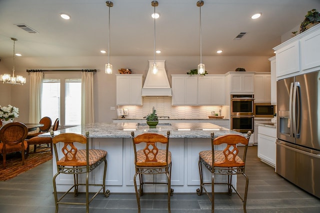 kitchen featuring visible vents, backsplash, appliances with stainless steel finishes, and premium range hood