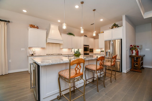 kitchen featuring custom exhaust hood, white cabinets, tasteful backsplash, and appliances with stainless steel finishes