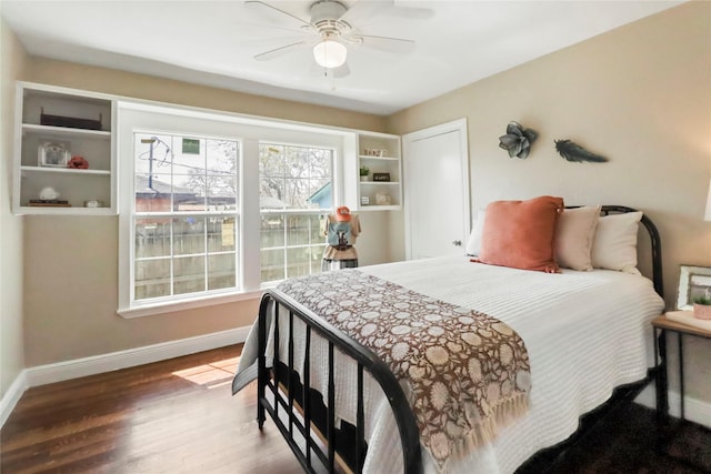 bedroom with ceiling fan, baseboards, and wood finished floors