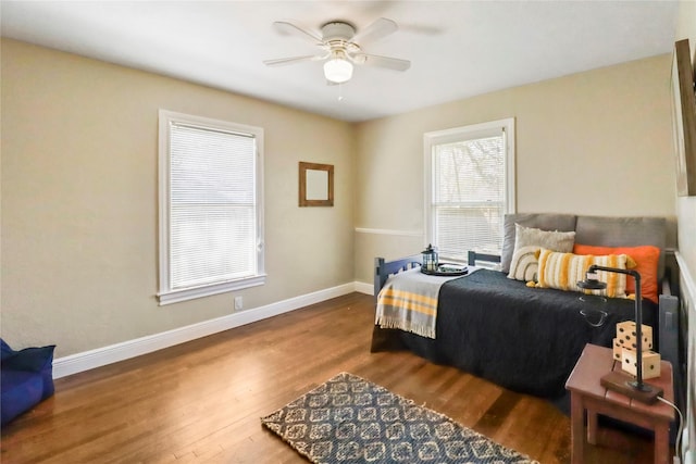 bedroom featuring a ceiling fan, baseboards, and wood finished floors