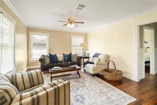 living room with visible vents, dark wood-type flooring, crown molding, a healthy amount of sunlight, and ceiling fan