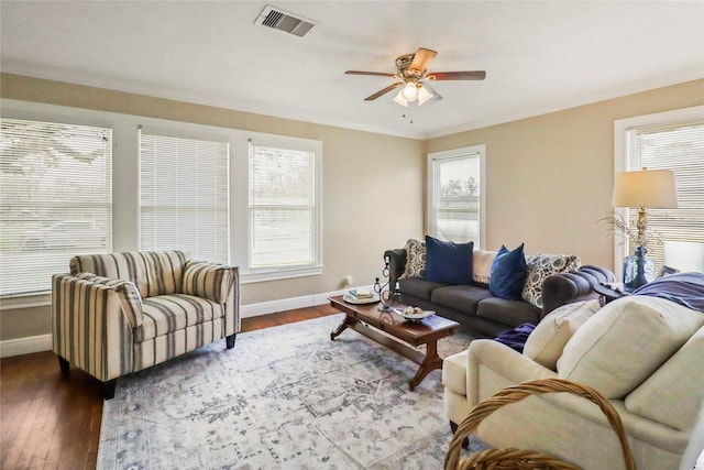 living area featuring dark wood-type flooring, a ceiling fan, visible vents, and baseboards