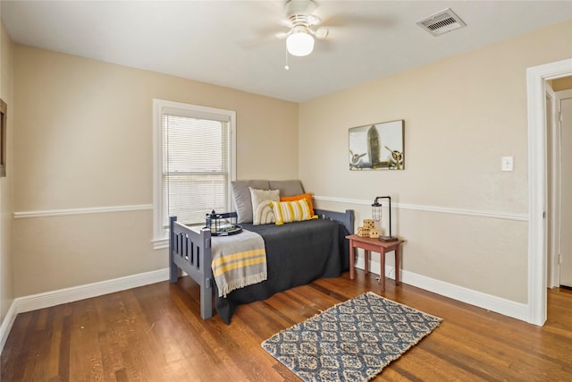 bedroom featuring ceiling fan, wood finished floors, visible vents, and baseboards