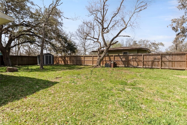 view of yard featuring a storage shed, an outdoor structure, and a fenced backyard