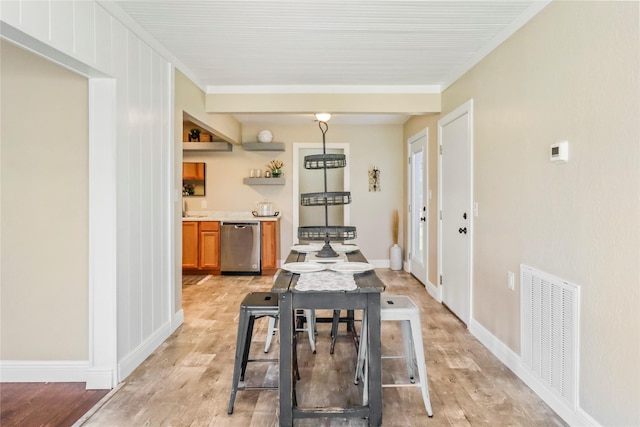 dining area with visible vents, light wood-style flooring, crown molding, and baseboards