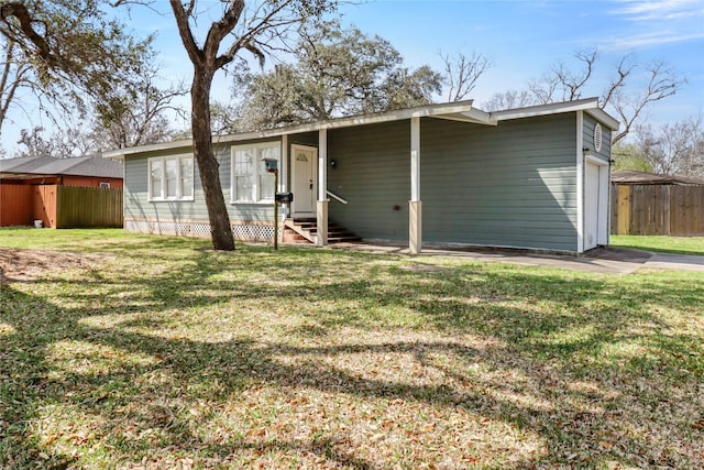 view of front facade with entry steps, an attached garage, a front lawn, and fence