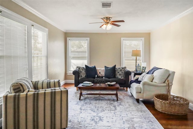 living area with visible vents, wood finished floors, ceiling fan, and crown molding