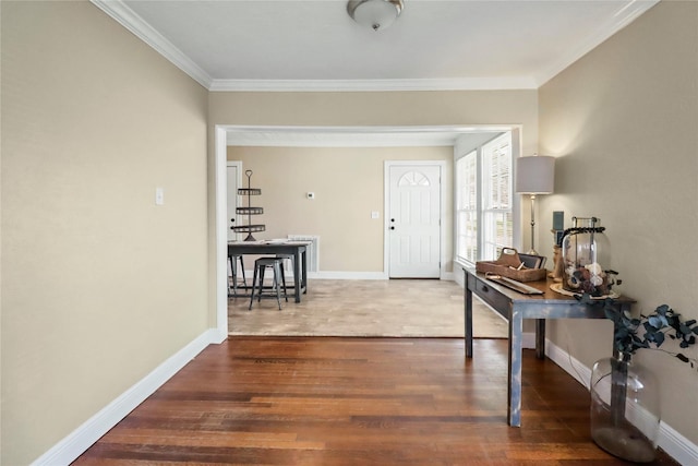 entryway featuring baseboards, wood finished floors, and ornamental molding